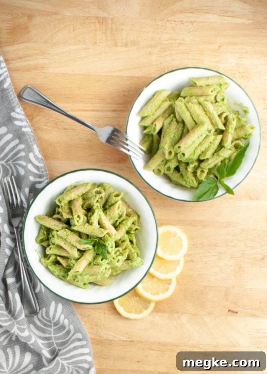 Avocado Cream Lemon Basil Pasta (Vegan & Gluten-Free) 4 Two bowls of creamy vegan avocado pasta, garnished with fresh basil, overhead shot.