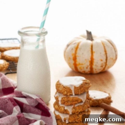 Frosted Vegan Gluten-Free Pumpkin Oatmeal Delights 7 gluten-free-dairy-free-iced-pumpkin-oatmeal-cookies-stacked-by-milk-and-a-mini-pumpkin