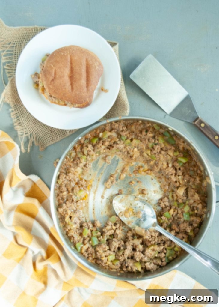 Dairy-Free Philly Cheesesteak Sloppy Joe Smash 55 gluten-free-dairy-free-philly-cheesesteak-mixture-in-a-skillet-with-a-bun-on-a-plate