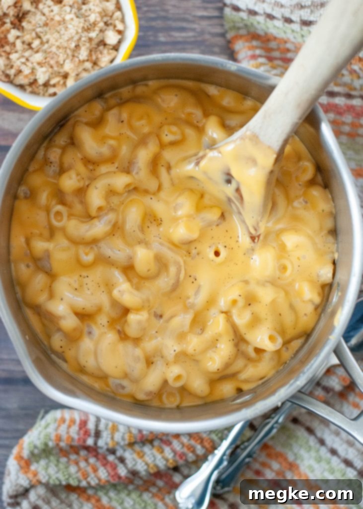 creamy gluten-free mac and cheese in a pot from above with a wooden spoon