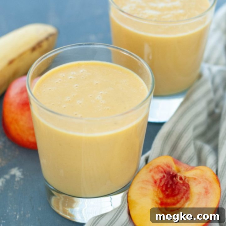 Peachy Dairy-Free Protein Boost 7 dairy-free peach protein smoothie in two glasses with fruit around it