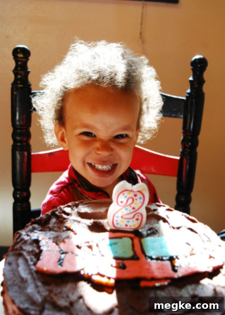 Two-year-old boy celebrating his birthday with cake and vegan chocolate frosting